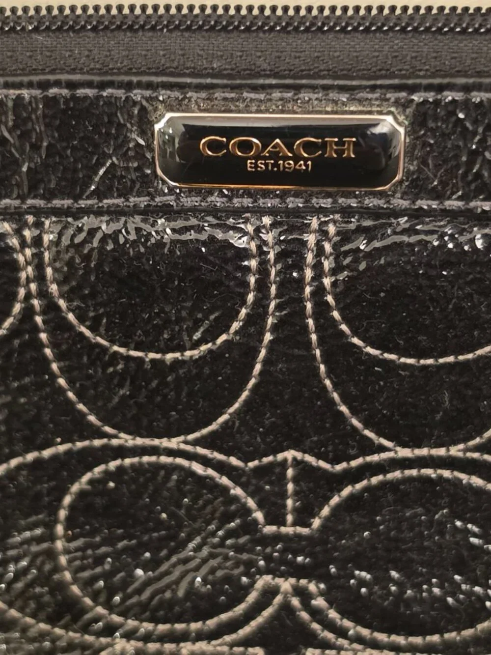 The Coach Signature Stitched Patent Leather Wristlet in black silver